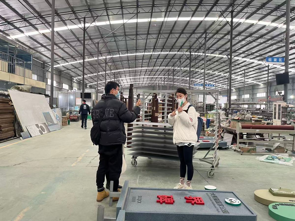 Two staff assembling marquee letters on the production floor