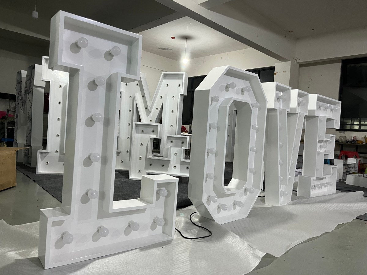 Illuminated marquee letters spelling LOVE in the workshop