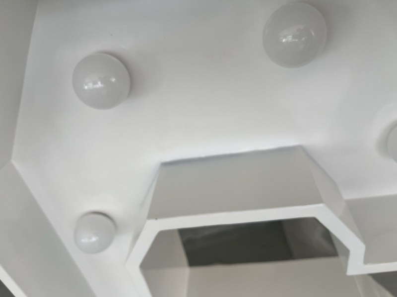 Bulbs seated in sockets on the punched metal face, with the internal brace visible